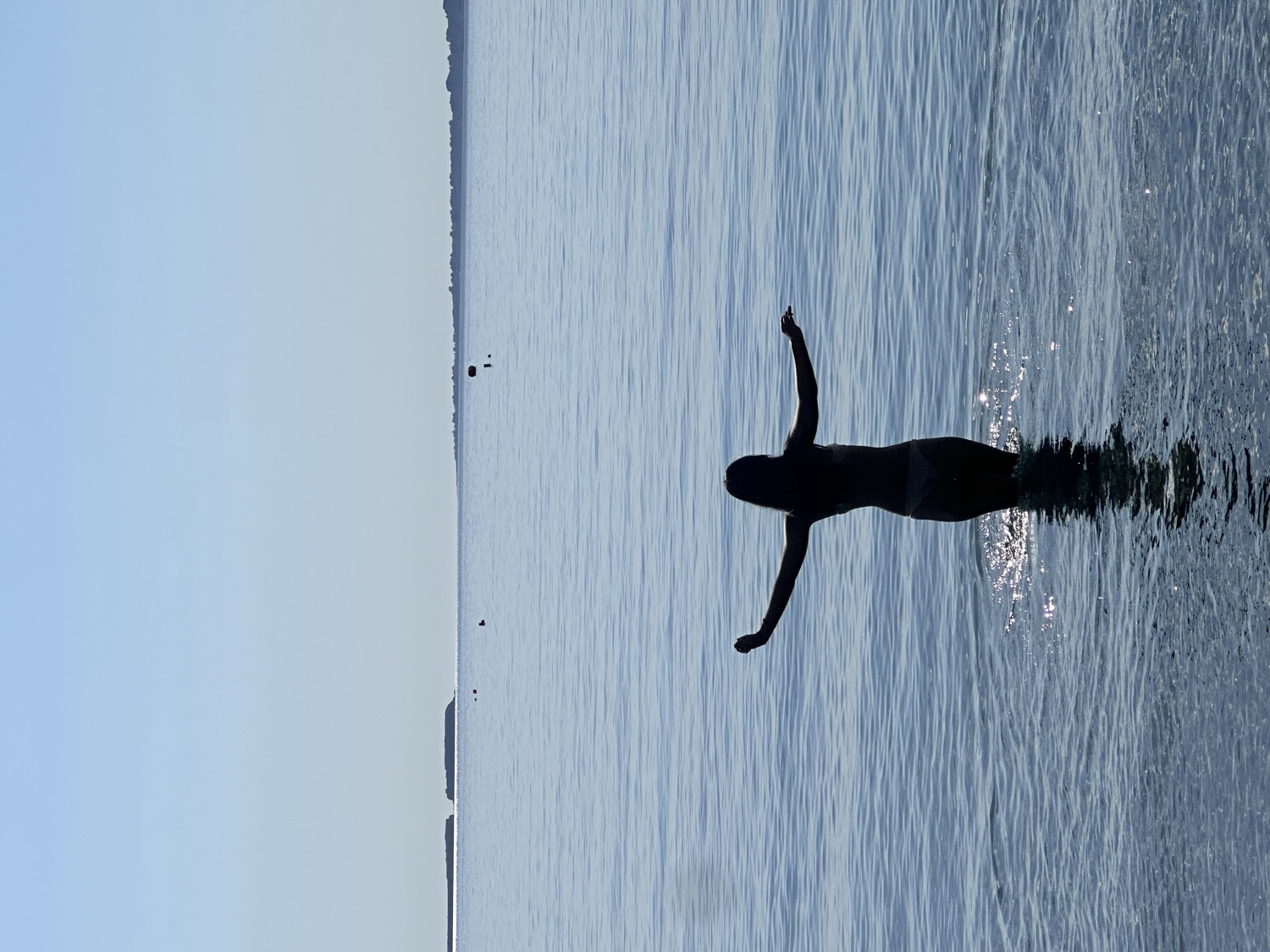Arms open in the sea, at the end of the day
