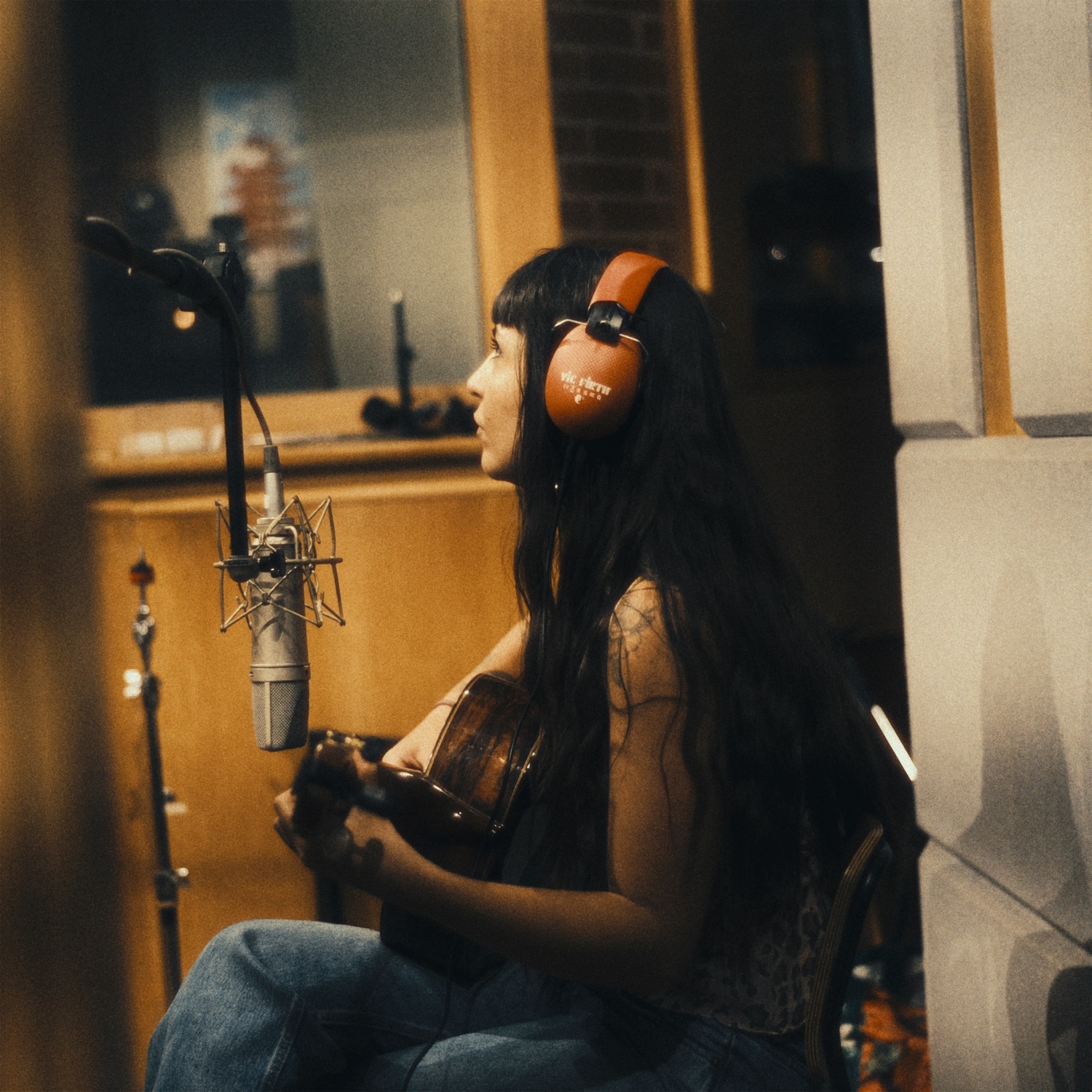 Dora at the mic, orange headphones